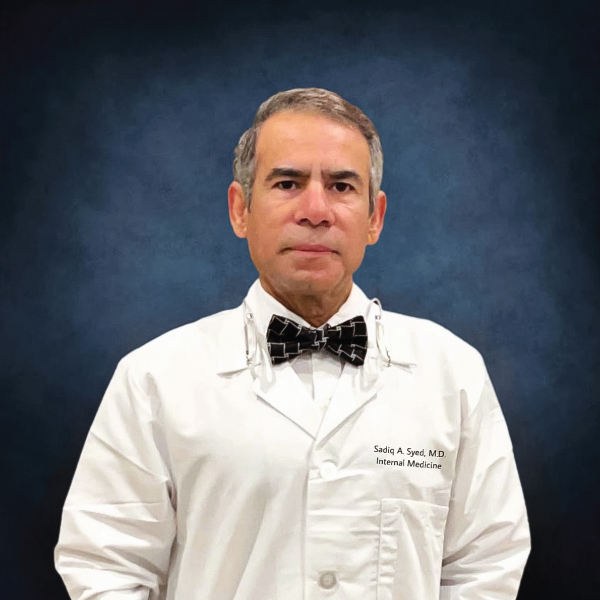 Dr. Sadiq A. Syed in a white coat and bow tie